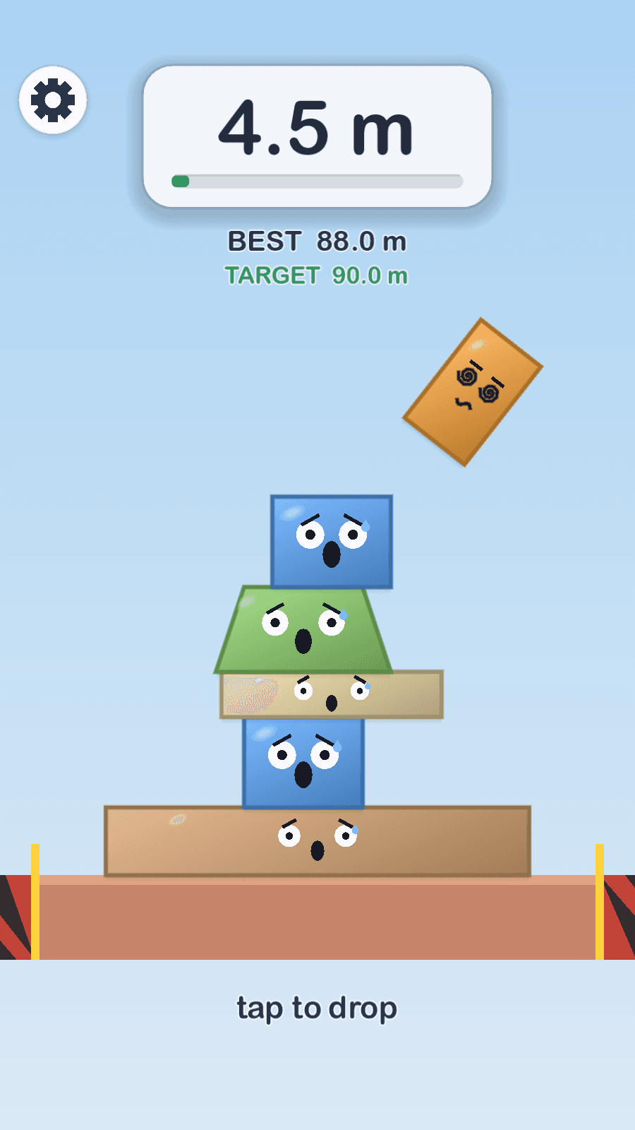 A Stackfall tower toppling, every block wearing a panicked face while the falling piece is knocked dizzy